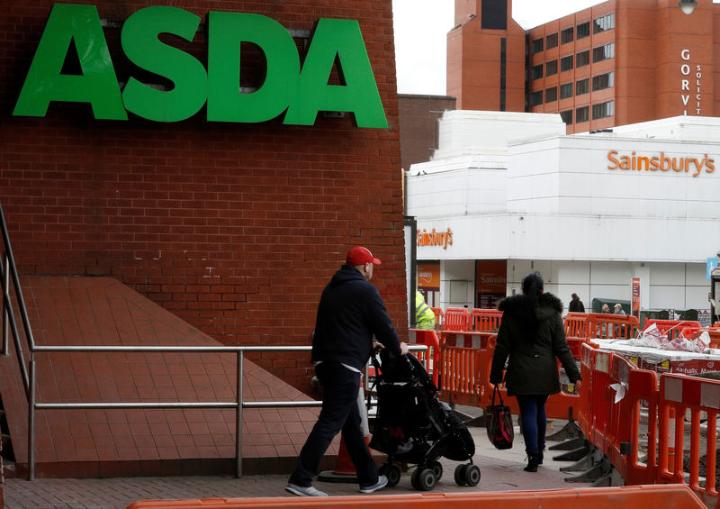 © Reuters. People walk past branches of ASDA and Sainsbury's in Stockport.