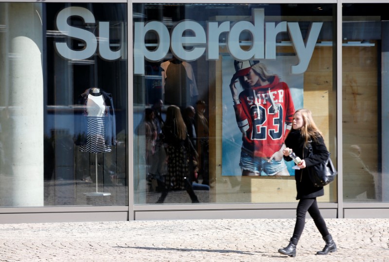 © Reuters. FILE PHOTO: A woman walks past a Superdry fashion store in Berlin