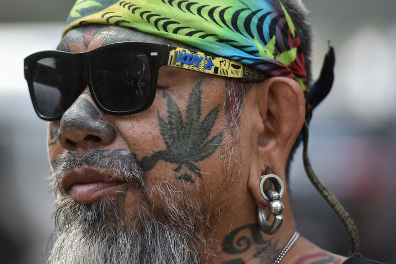 © Reuters. A Thai activist with a marijuana tattoo on his face gathers with others during a campaign for the legalisation of medical marijuana near Government House in Bangkok