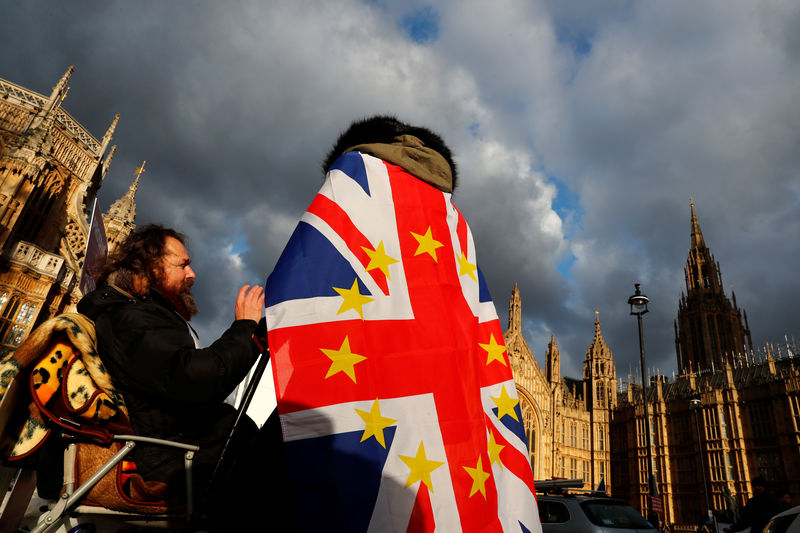© Reuters. An anti-Brexit demonstrator wears a Union flag decorated with the stars of the EU flag opposite the Houses of Parliament in London