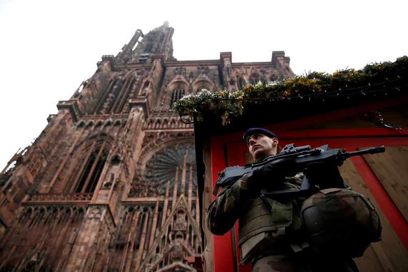 © Reuters. A French soldier stands guard near a closed wooden barrack shop at the traditional Christkindelsmaerik (Christ Child market) in front of the Cathedral the day after a shooting in Strasbourg