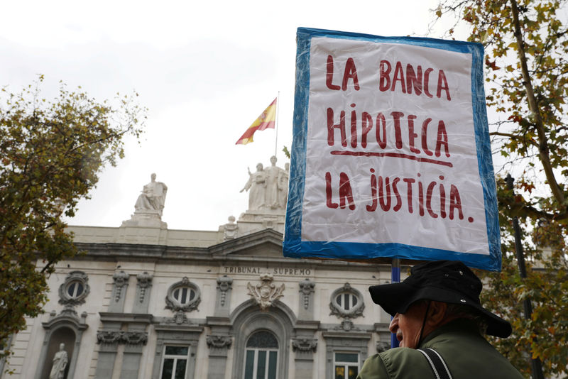 © Reuters. FILE PHOTO: A man holds a banner reading "Banks mortgage justice" during a demonstration by activists from 'The Mortgage Victims' Association'  in Madrid