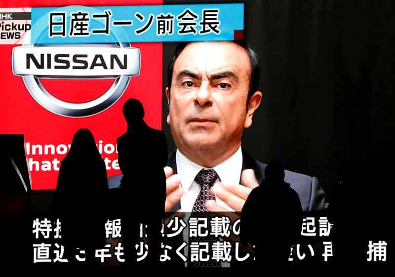 © Reuters. Passersby are silhouetted as a huge street monitor broadcasts news reporting ousted Nissan Motor chairman Carlos Ghosn's indictment and re-arrest in Tokyo