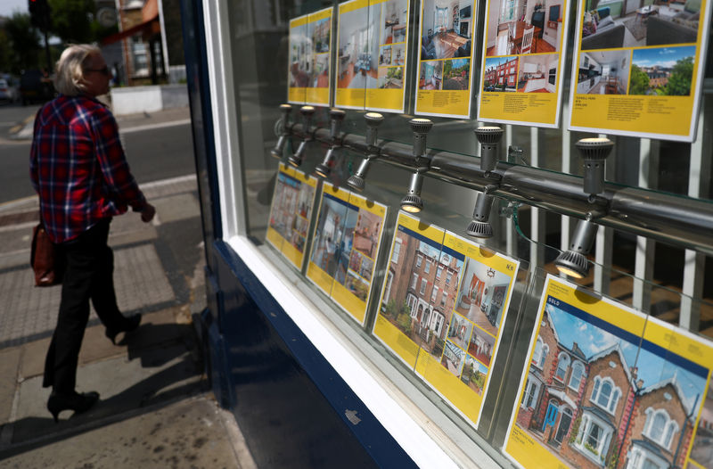 © Reuters. A woman passes the window of an estate agent in London