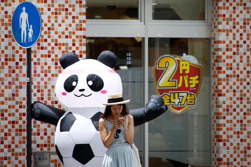 © Reuters. A woman uses her mobile phone at a shopping district in Tokyo