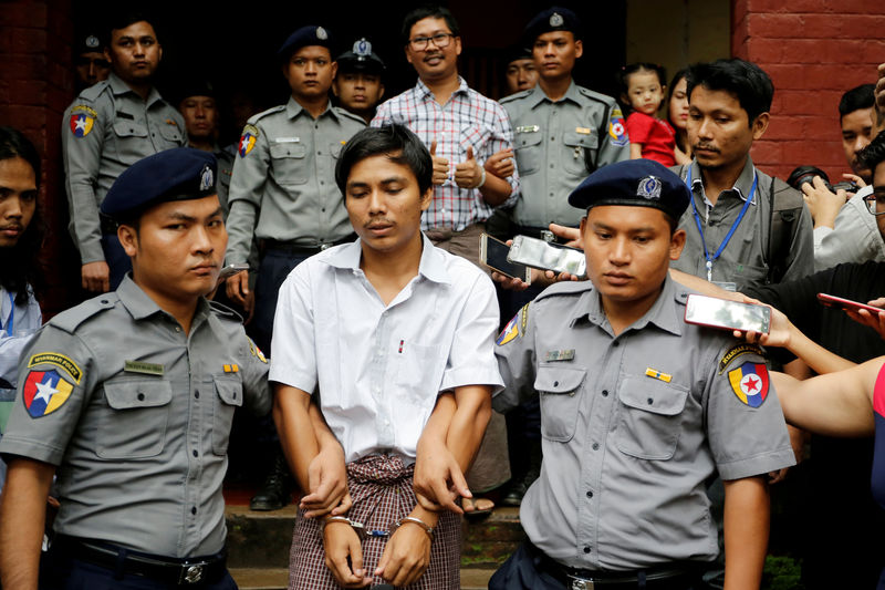 © Reuters. FILE PHOTO: Detained Reuters journalist Kyaw Soe Oo and Wa Lone are escorted by police as they leave after a court hearing in Yangon