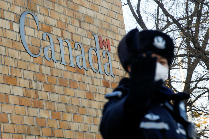 © Reuters. Un policía gesticula ante un fotógrafo en el exterior de la Embajada de Canadá en Pekín, China.