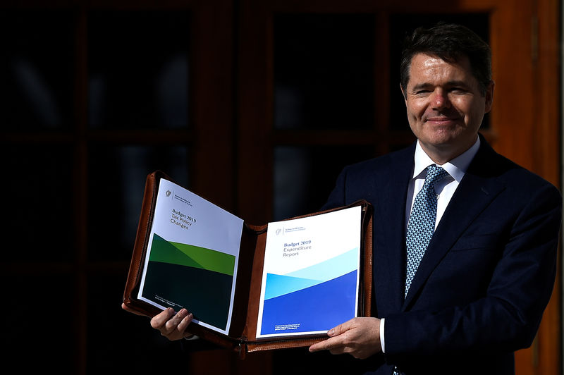 © Reuters. Ireland's Minister for Finance Paschal Donohoe displays a copy of the 2019 budget on the steps of Government Buildings in Dublin