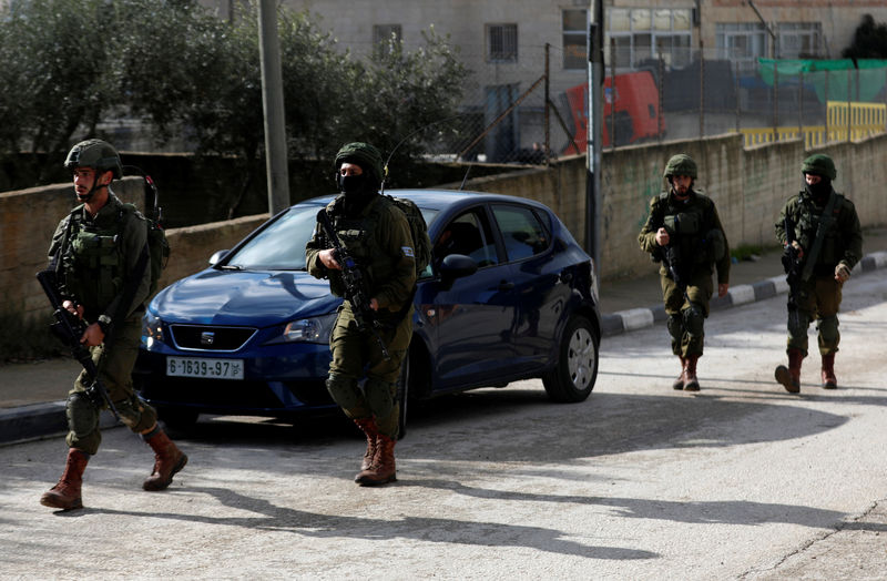 © Reuters. Israeli forces walk during a raid in Ramallah in the Israeli-occupied West Bank