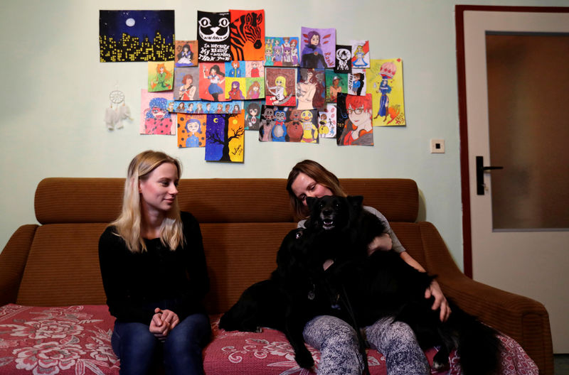 © Reuters. Ludmila Krivkova and her daughter Michaela play with their dogs at their apartment in Usti nad Labem