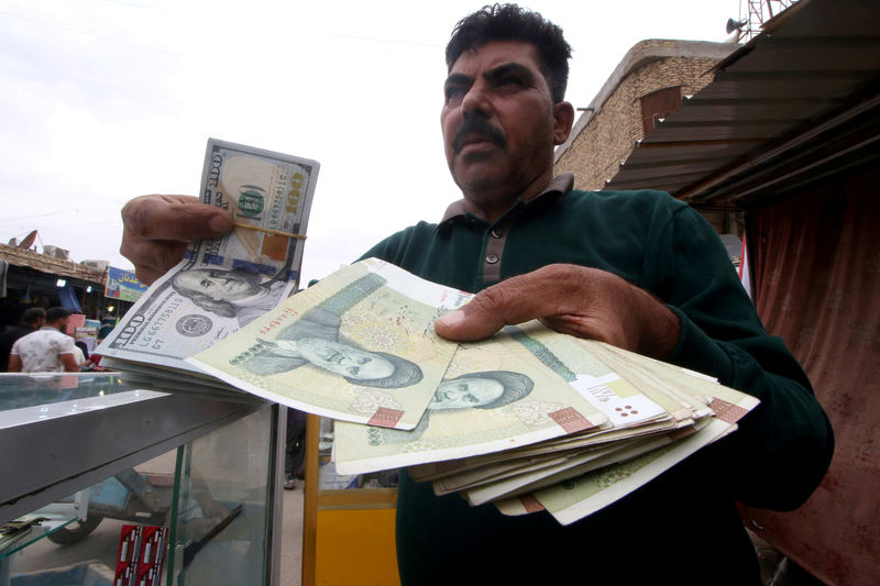 © Reuters. FILE PHOTO: A man holds Iranian rials at a currency exchange shop in Basra, Iraq