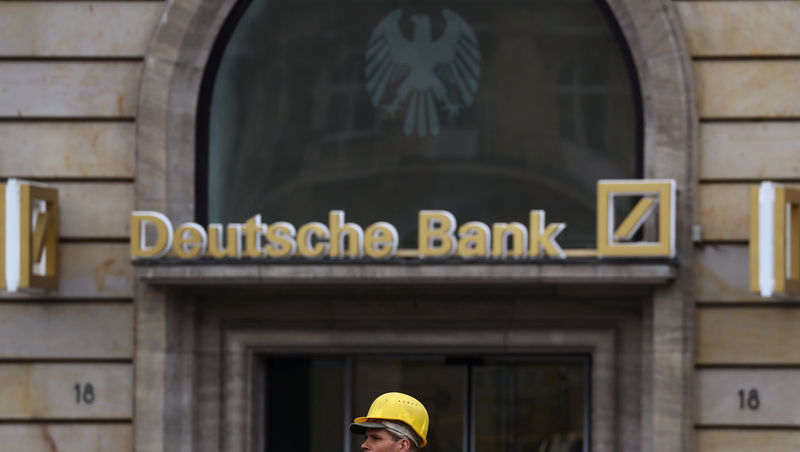 © Reuters. A construction worker walks past a branch of Germany's largest business bank, Deutsche Bank in Frankfurt