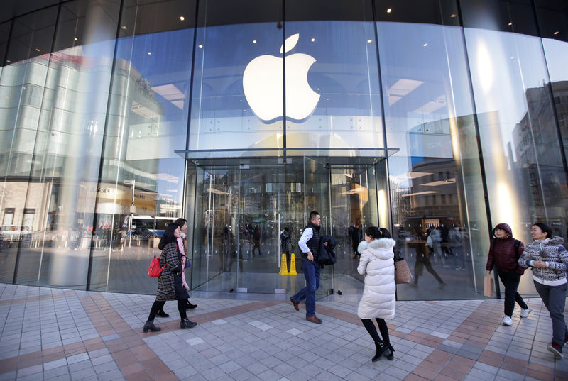 © Reuters. People walk outside an Apple store in Beijing