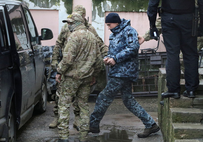 © Reuters. Militares russos escoltam marinheiro ucraniano detido em Simferopol