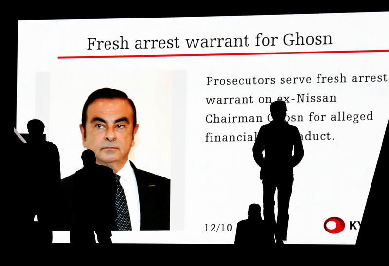 © Reuters. Passersby are silhouetted as a huge street monitor broadcasts news reporting ousted Nissan Motor chairman Carlos Ghosn's indictment and re-arrest in Tokyo