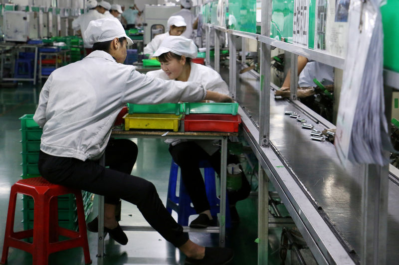 © Reuters. FILE PHOTO: Employees work at a production line of lithium ion batteries inside a factory in Dongguan