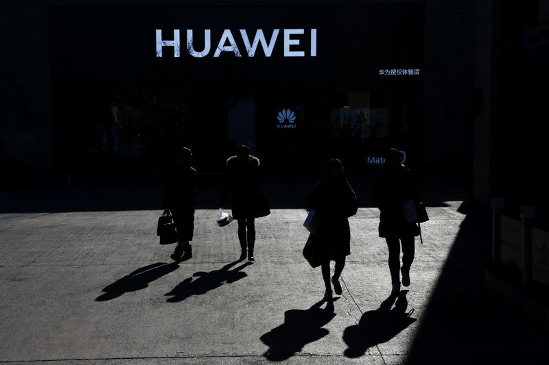 © Reuters. People walk past a Huawei shop in Beijing