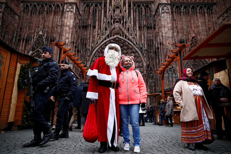 © Reuters. French police patrol outside the Strasbourg Cathedral as a man dressed as Father Christmas poses with a tourist