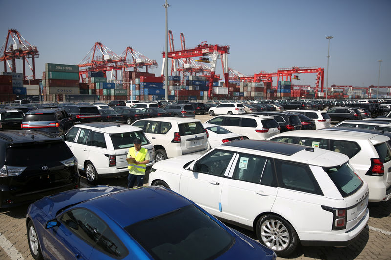 © Reuters. Worker inspects imported cars at a port in Qingdao