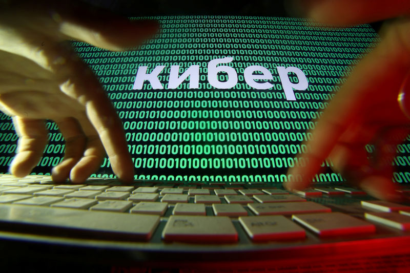 © Reuters. Hands are seen on a keyboard in front of a displayed cyber code in this picture illustration