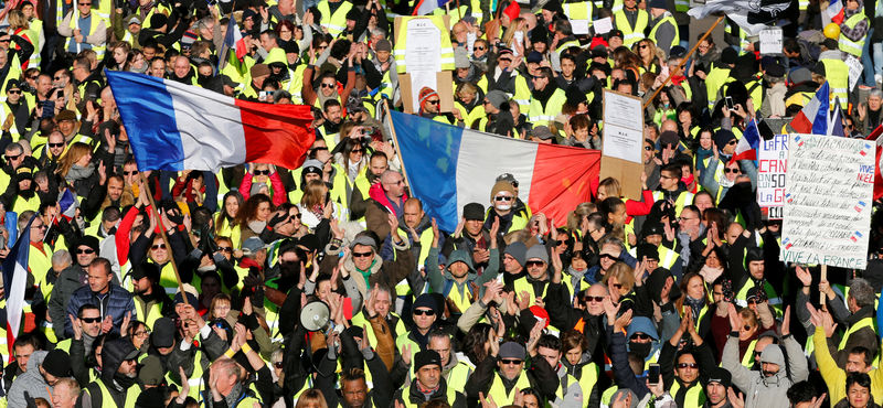 © Reuters. Manifestantes con chalecos amarillos ondean banderas francesas mientras participan en una manifestación del movimiento "chalecos amarillos" en Marsella