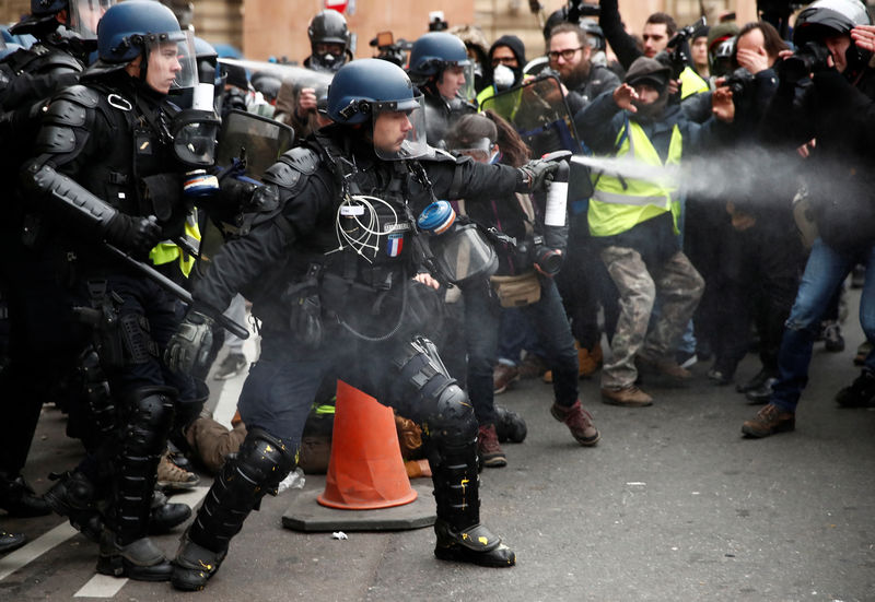 © Reuters. Gendarmes franceses usan gas pimienta para hacer retroceder a manifestantes durante una protesta de "chalecos amarillos" en París.