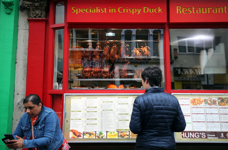 © Reuters. FILE PHOTO - People stand outside a restaurant in Chinatown in London
