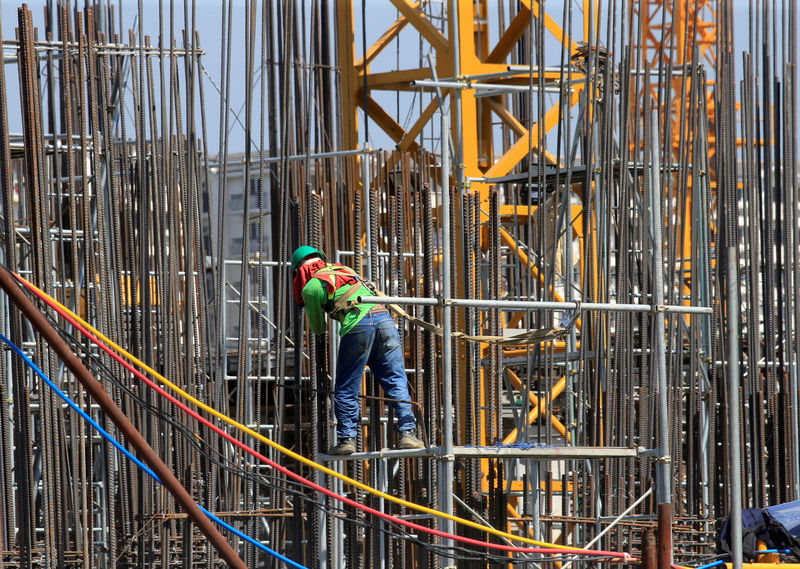 © Reuters. FILE PHOTO A worker installs steel rods at a construction site in Paranaque city, metro Manila