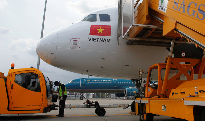 © Reuters. FILE PHOTO: A worker pumps fuel into a Vietjet Air A320 aircraft, in front of a Vietnam Airlines aircraft at Tan Son Nhat airport in Vietnam's southern Ho Chi Minh city