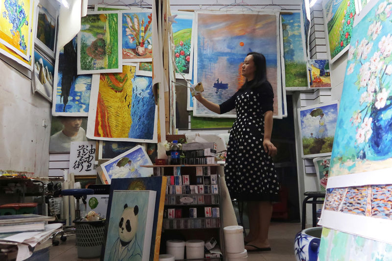 © Reuters. Ma Chunyan, de 32 años, trabaja en la reproducción de una obra maestra a partir de una imagen del original en su teléfono móvil, en Shenzhen