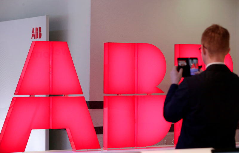 © Reuters. Мужчина фотографирует логотип ABB перед пресс-конференцией компании в Цюрихе