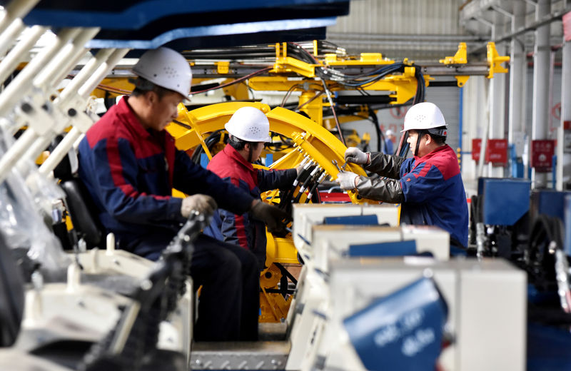 © Reuters. FILE PHOTO: Employees work on a drilling machine production line at a factory in Zhangjiakou
