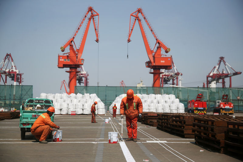 © Reuters. FILE PHOTO: Workers paint the ground at a port in Qingdao