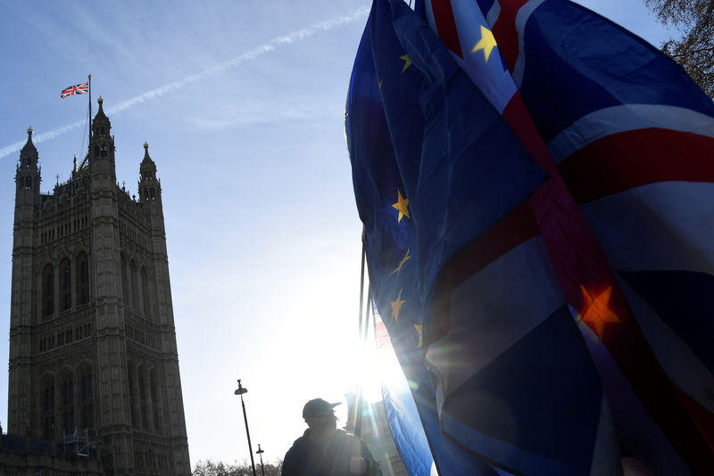 © Reuters. A demonstrator holds EU and Union flags during an anti-Brexit protest opposite the Houses of Parliament in London
