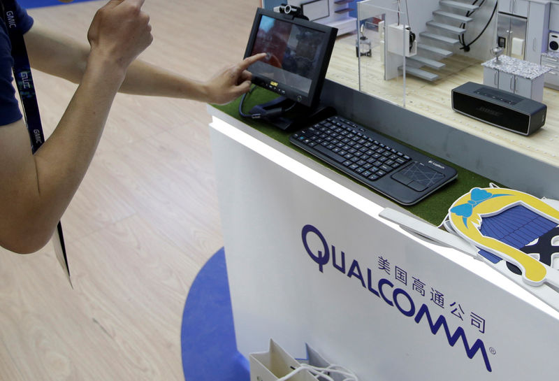 © Reuters. FILE PHOTO: A man visits Qualcomm's booth at the GMIC in Beijing