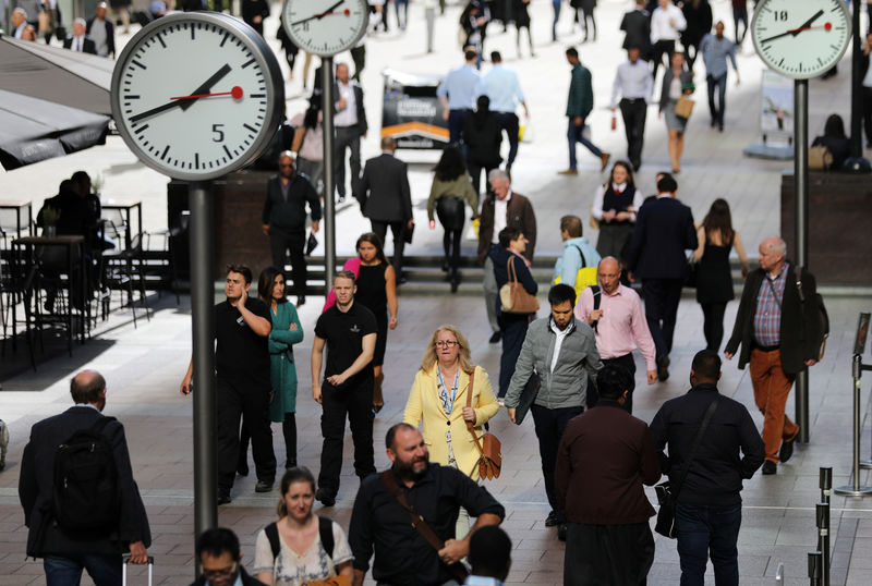 © Reuters. FILE PHOTO: People walk through the financial district of Canary Wharf, London