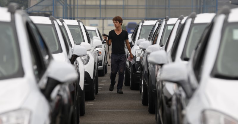 © Reuters. A worker checks cars made by GM Korea in a yard of GM Korea's Bupyeong plant in Incheon
