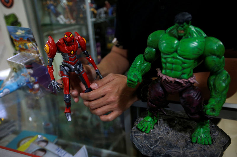 © Reuters. Andy Kurniawan, who is the owner of an action figure store, shows action figures at his store in Jakarta