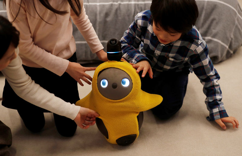 © Reuters. Children touch Groove X's Lovot at its demonstration during the launching event in Tokyo