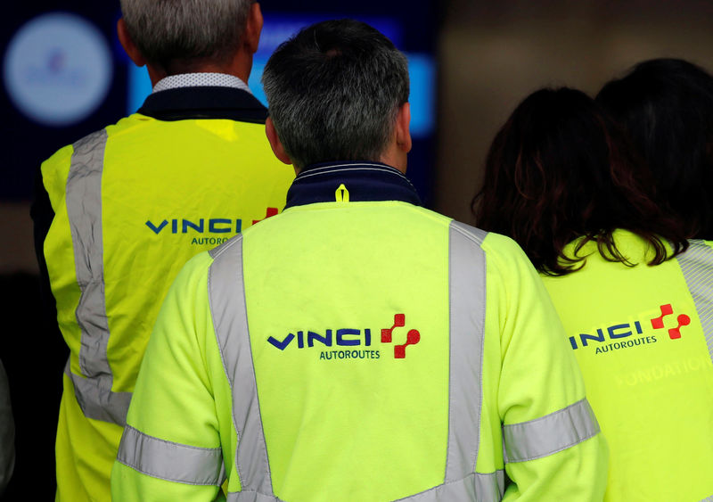© Reuters. The Vinci logo is seen on jackets during a visit a a mobile factory installed to produce tons of recycled asphalt near the A10 motorway in Gironde for a test for the first "100% recycled" road by Eurovia
