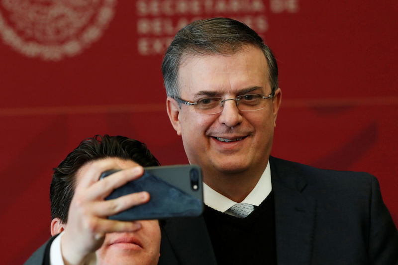 © Reuters. A man takes a selfie with Mexico's Foreign Minister Marcelo Ebrard after announcing a joint development plan between Mexico and the United States for the northern triangle of Central America, in Mexico City