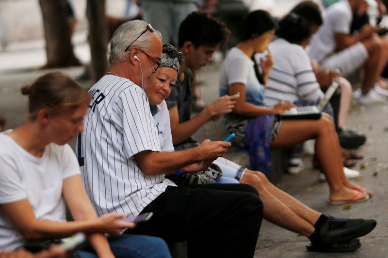 © Reuters. People use the internet at a hotspot in Havana, Cuba