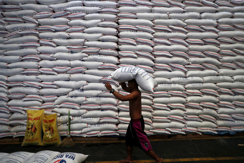 © Reuters. FILE PHOTO: A worker carries on his head a sack of rice inside a government rice warehouse National Food Authority in Quezon city, Metro Manila