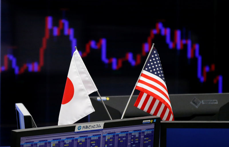 © Reuters. FILE PHOTO:  National flags of Japan and the U.S. are seen in front of a monitor showing a graph of the Japanese yen's exchange rate against the U.S. dollar at a foreign exchange trading company in Tokyo