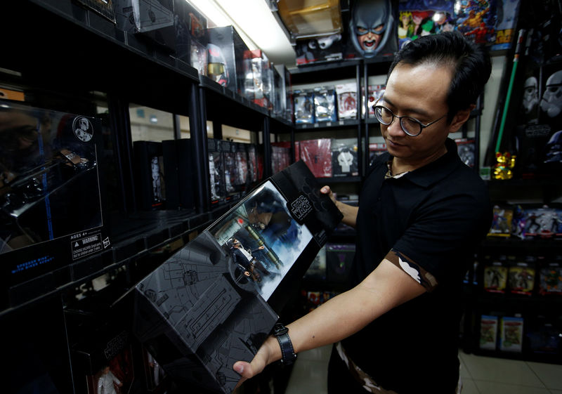 © Reuters. Andy Kurniawan, propietario de una tienda de figuras de acción coleccionables, muestra una caja con personajes de Star Wars en su local en Yakarta