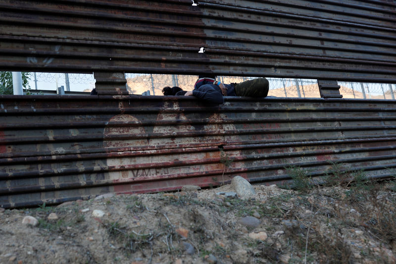 © Reuters. Imigrantes de caravana da América Central tentam entrar nos EUA através da fronteira no México