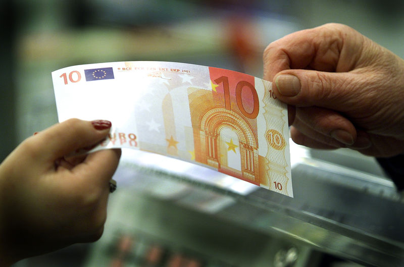 © Reuters. A TEN EURO NOTE CHANGES HANDS AT A SUPERMARKET NEAR MILAN.