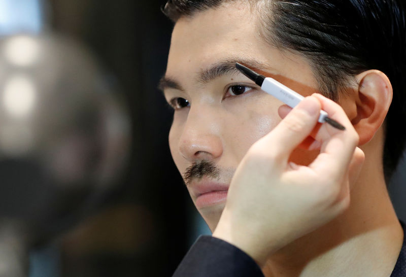 © Reuters. Model Masafumi is made up by make-up artist Hiroki using Pola Orbis subsidiary Acro's cosmetics during their demonstration at a department store in Tokyo