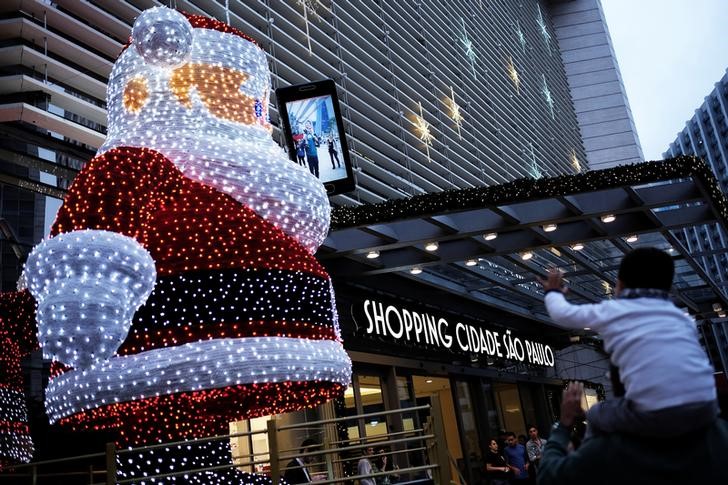 © Reuters. Pessoas entram em shopping enfeitado para o Natal em São Paulo