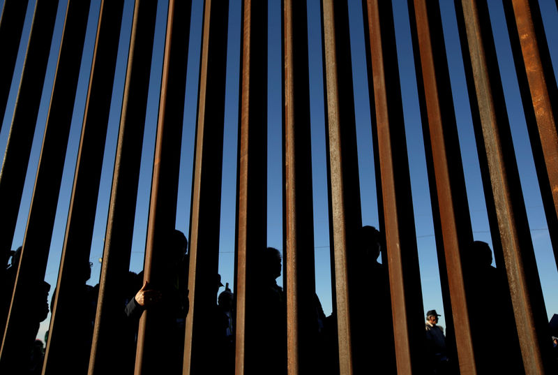 © Reuters. FILE PHOTO: People gather on the U.S. side of the border fence between Mexico and the United States during an inter-religious service against U.S. President Donald Trump's border wall, in Ciudad Juarez